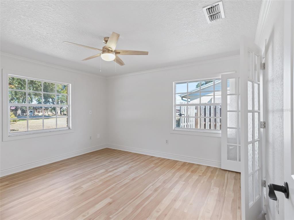10916 Southeast Timucuan Road Summerfield, FL 34491 - Photo 17 of 40 a view of an empty room with a window and wooden floor