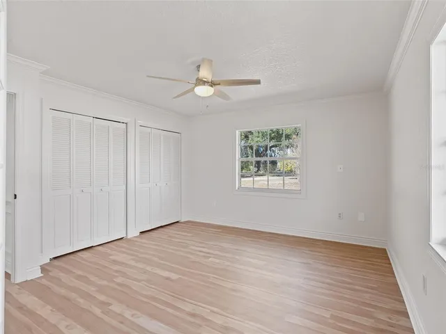 a view of a livingroom with wooden floor and a ceiling fan