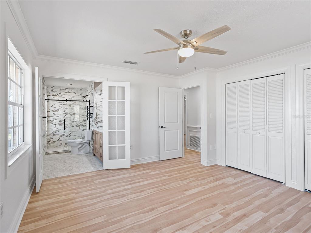 10916 Southeast Timucuan Road Summerfield, FL 34491 - Photo 19 of 40 a view of a livingroom with wooden floor and a ceiling fan