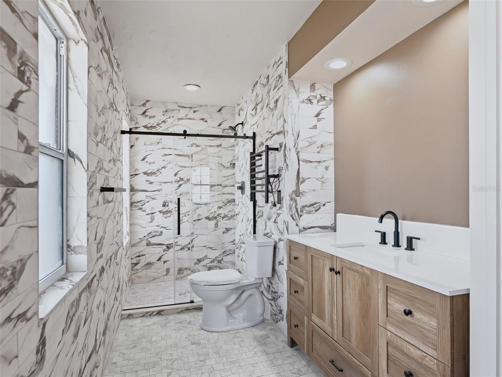 10916 Southeast Timucuan Road Summerfield, FL 34491 - Photo 20 of 40 a bathroom with a toilet sink and shower