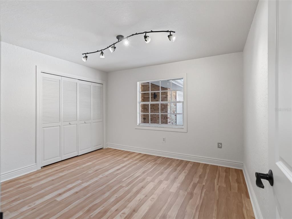 10916 Southeast Timucuan Road Summerfield, FL 34491 - Photo 24 of 40 a view of empty room with wooden floor and fan