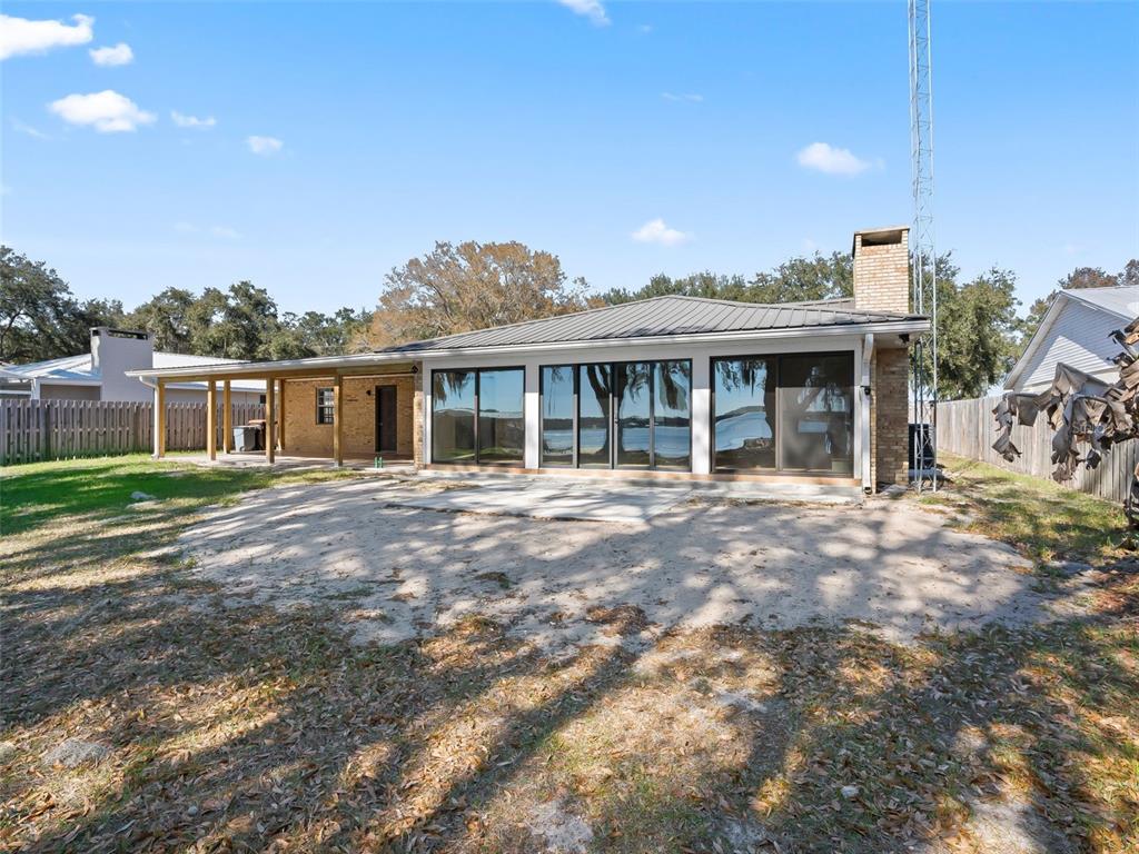 10916 Southeast Timucuan Road Summerfield, FL 34491 - Photo 32 of 40 a view of a house with a backyard and porch