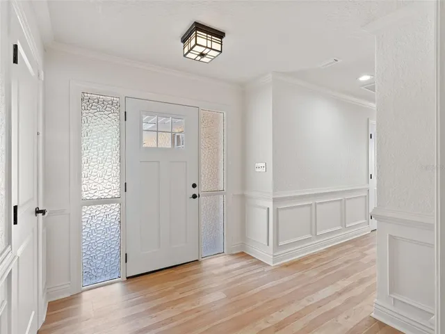 a view of an empty room with wooden floor and windows