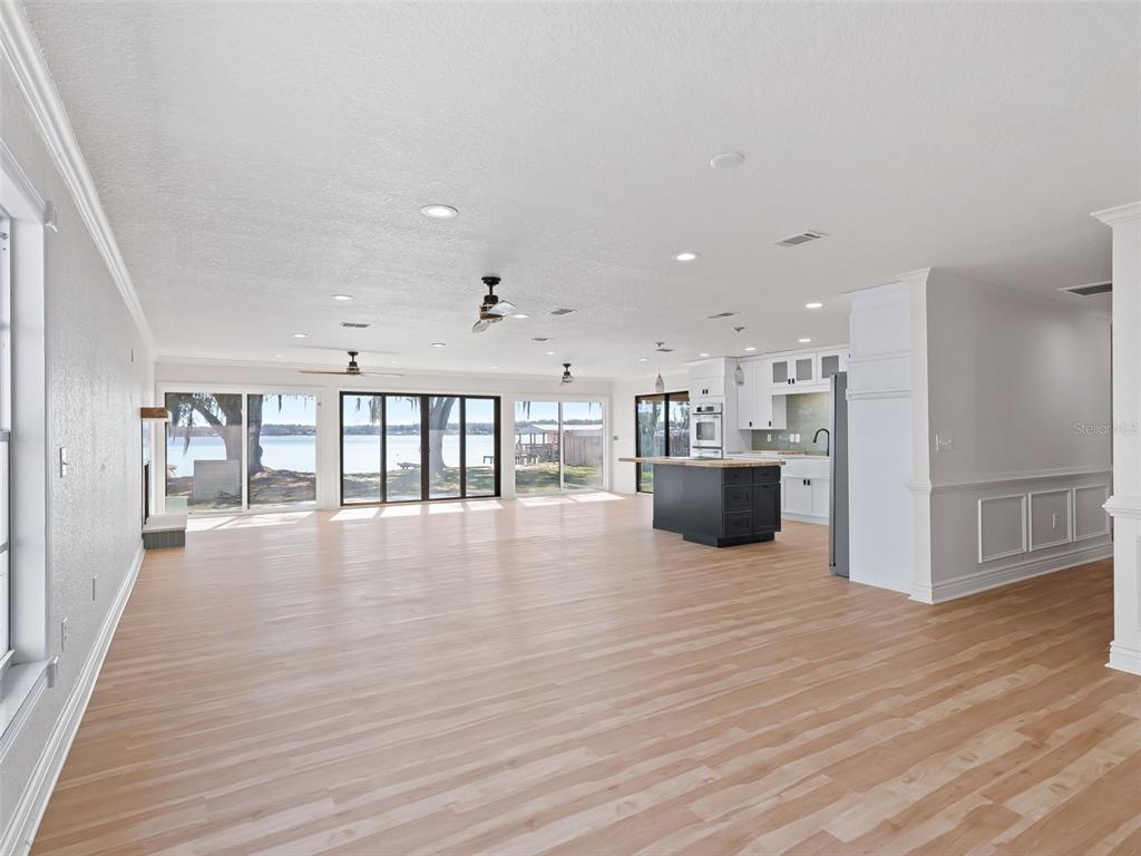 10916 Southeast Timucuan Road Summerfield, FL 34491 - Photo 5 of 40 a view of an empty room with wooden floor and windows