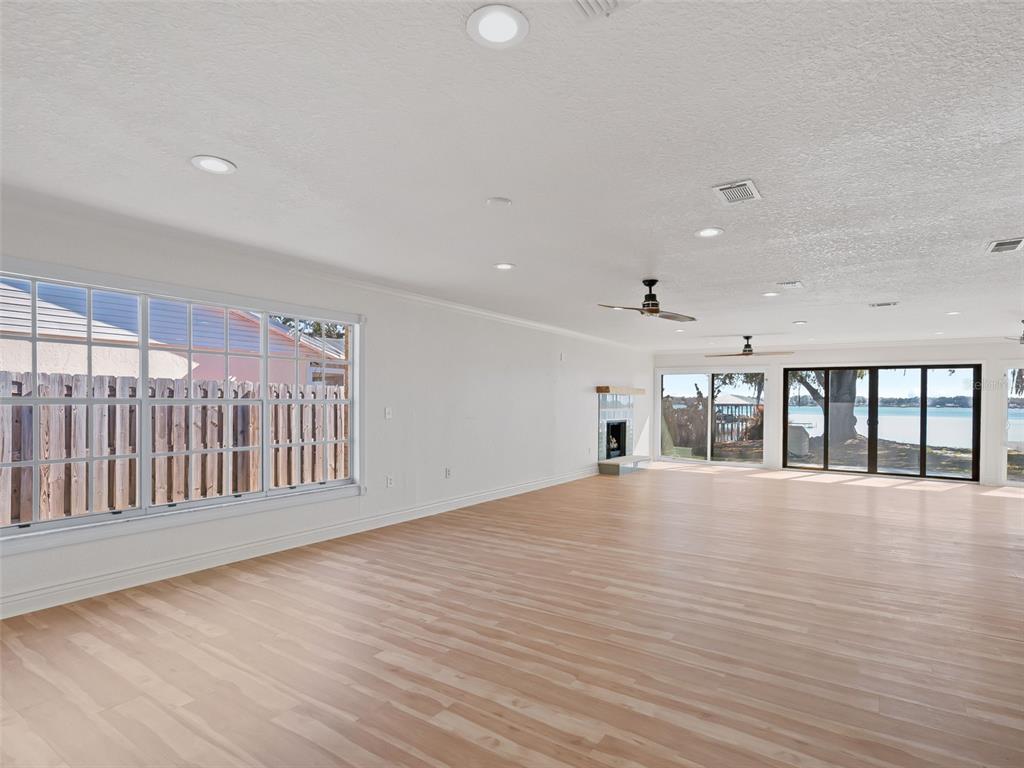 10916 Southeast Timucuan Road Summerfield, FL 34491 - Photo 6 of 40 an empty room with wooden floor and windows