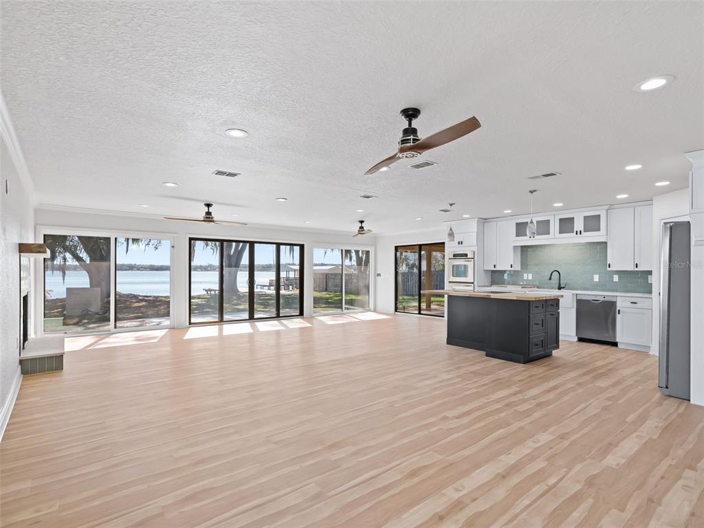 10916 Southeast Timucuan Road Summerfield, FL 34491 - Photo 8 of 40 a large kitchen with stainless steel appliances granite countertop a large counter top and a wooden floors