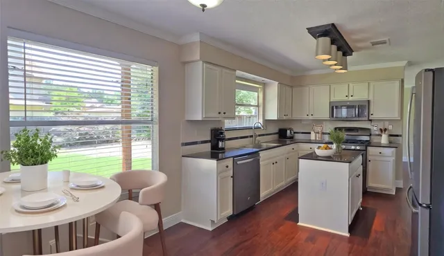 a kitchen with a refrigerator sink and wooden floor