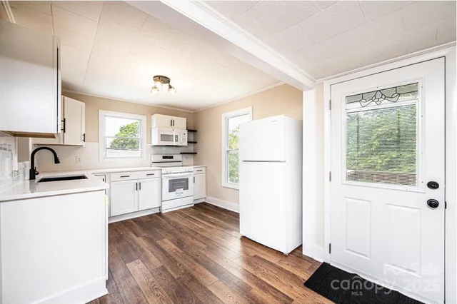 a kitchen with white cabinets and white appliances