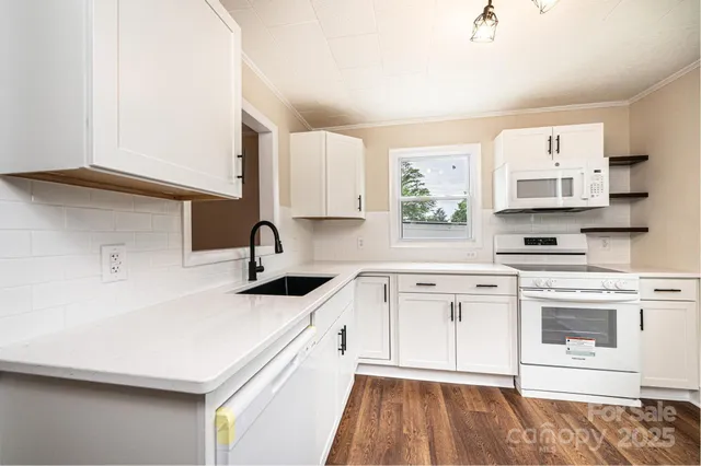 a kitchen with stainless steel appliances white cabinets a sink and a stove