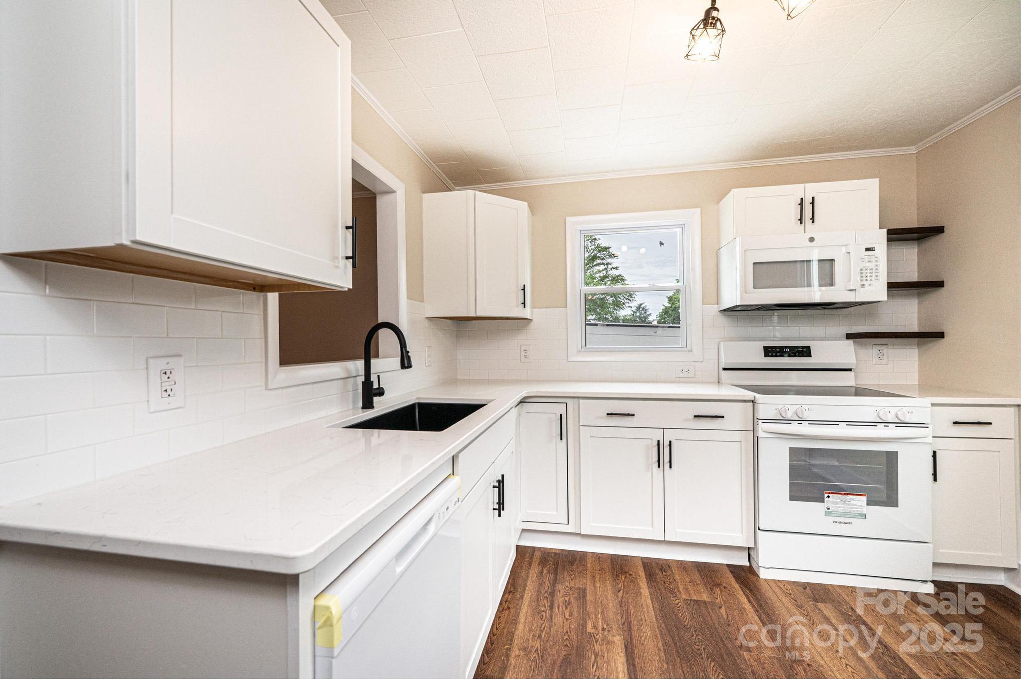 210 West 15th Street Newton, NC 28658 - Photo 17 of 43 a kitchen with stainless steel appliances white cabinets a sink and a stove
