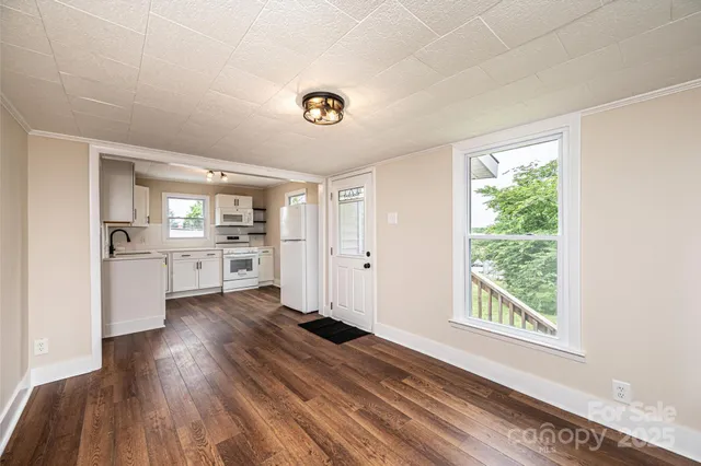 a view of a kitchen with wooden floor and a kitchen space