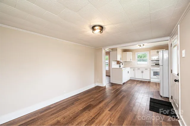 a view of a kitchen with wooden floor and windows