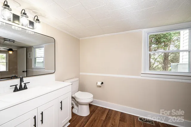 a bathroom with a sink a toilet and a window