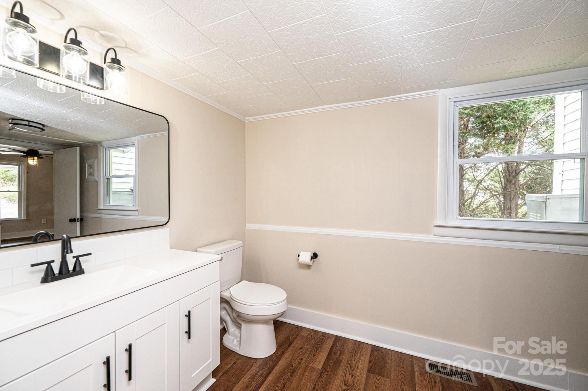 210 West 15th Street Newton, NC 28658 - Photo 26 of 43 a bathroom with a sink a toilet and a window