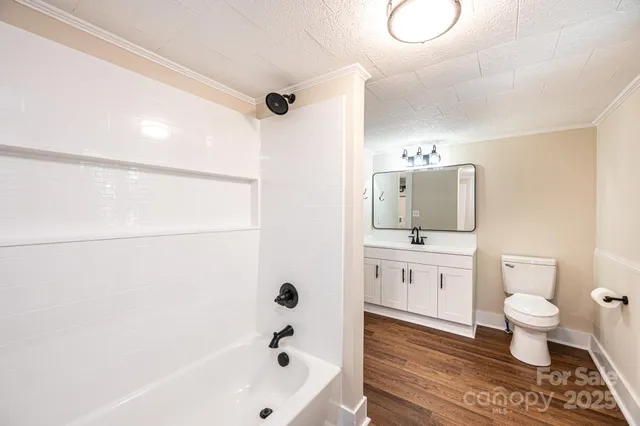 a bathroom with a bathtub shower sink mirror and toilet
