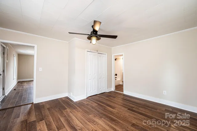 a view of a room with wooden floor and ceiling fan