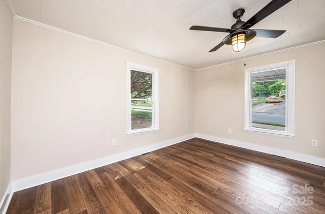 an empty room with a window and a ceiling fan