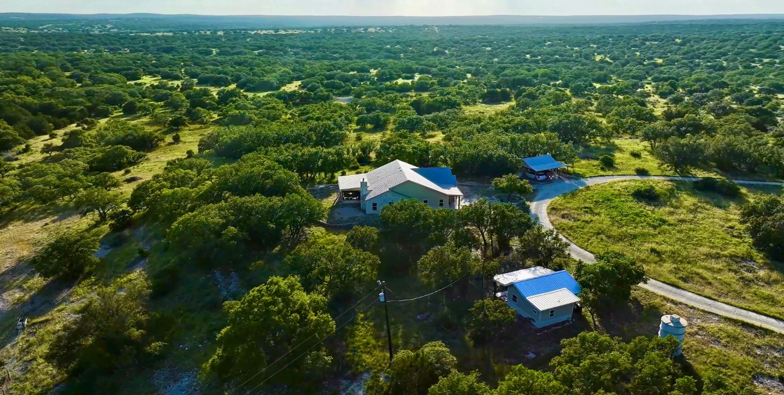 an aerial view of residential house with outdoor space and trees