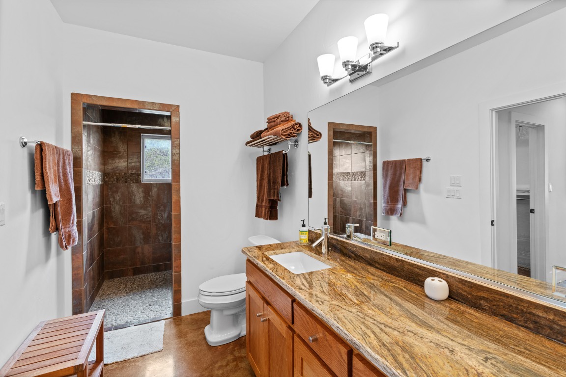 2321 Gentry Creek Road Menard, TX 76859 - Photo 21 of 35 a bathroom with a granite countertop sink a toilet and a mirror