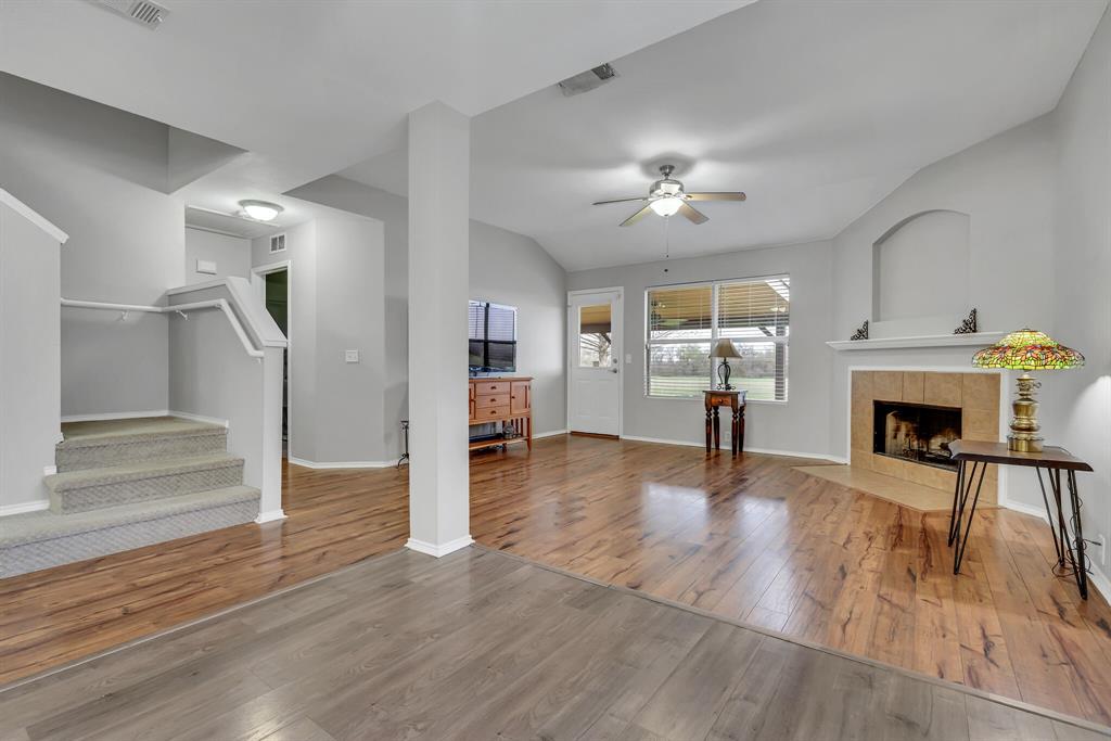 3616 Riesling Drive Denton, TX 76226 - Photo 3 of 18 Living area featuring a ceiling fan, lofted ceiling, wood-type flooring, stairs, and a fireplace