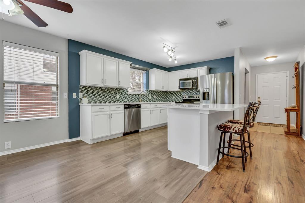3616 Riesling Drive Denton, TX 76226 - Photo 7 of 18 Kitchen with white cabinetry, visible vents, stainless steel appliances, and decorative backsplash