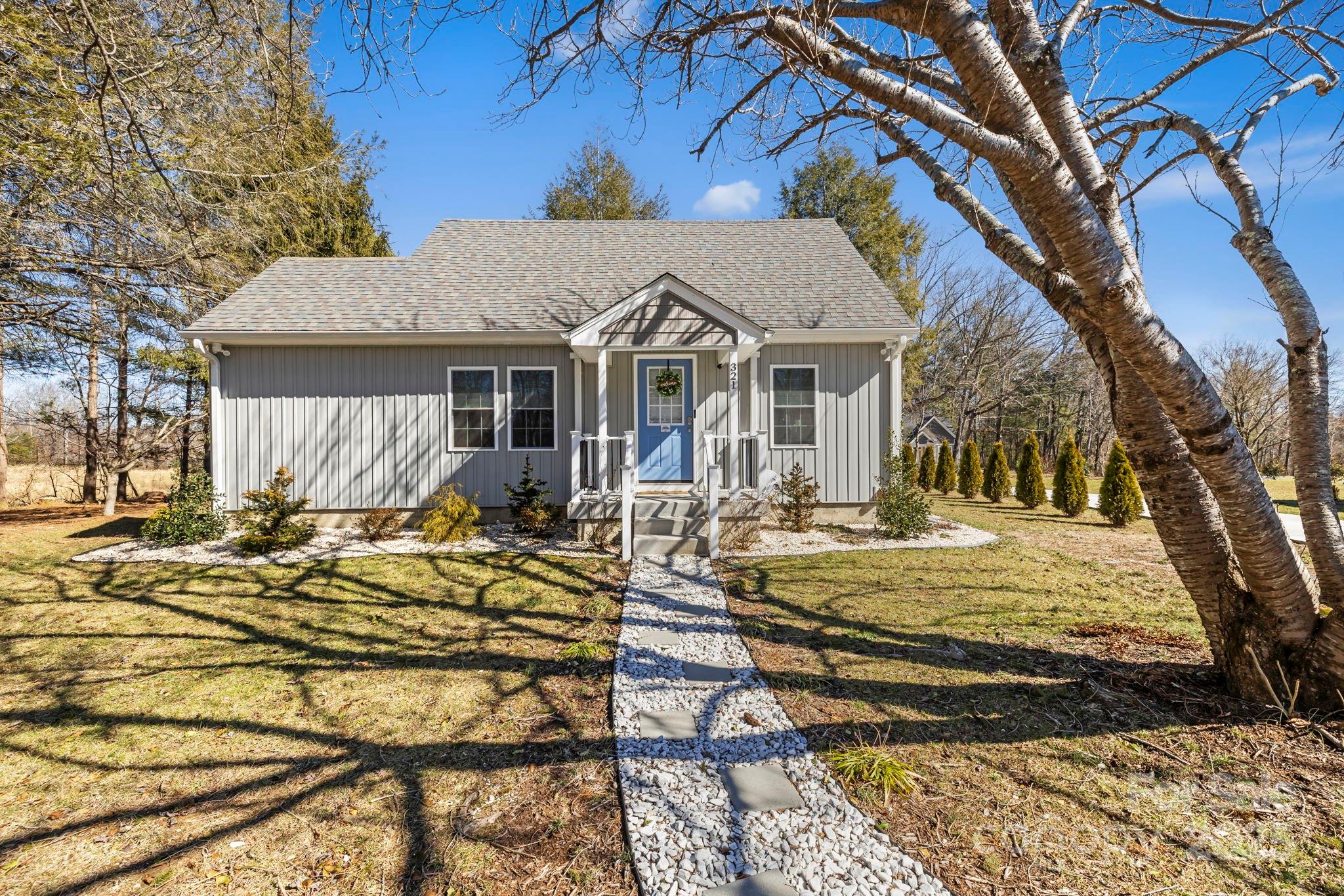 321 Ballenger Road Flat Rock, NC 28731 - Photo 4 of 32 a view of a white house with a chairs and table in a patio