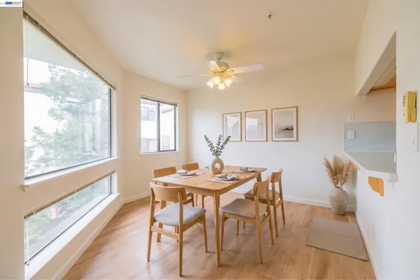 a view of a room with wooden floor and a ceiling fan