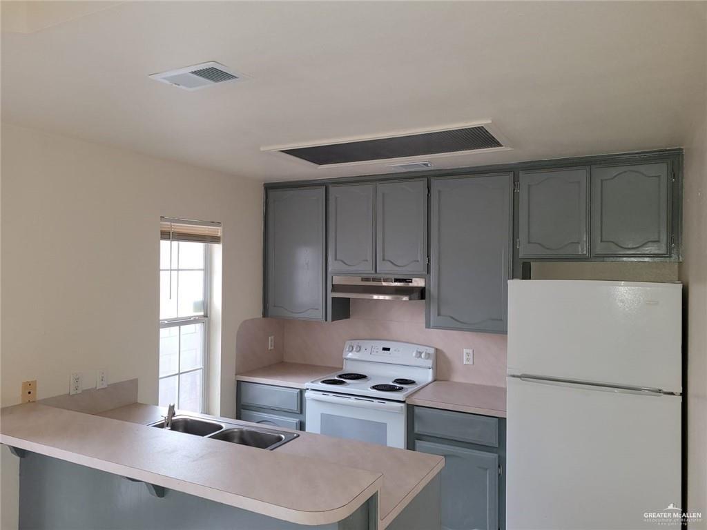 6804 North 8th Street McAllen, TX 78504 - Photo 7 of 11 a kitchen with a sink a stove and refrigerator