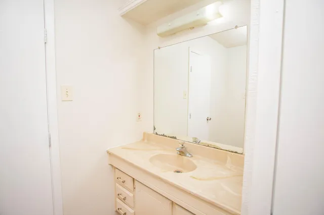 a view of a room with a ceiling fan and wooden floor