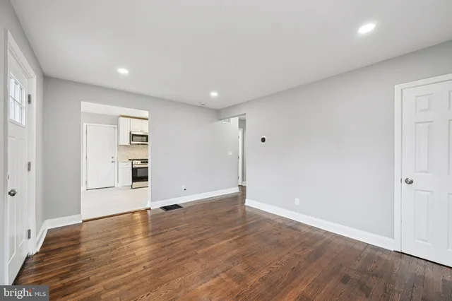 a view of an empty room with wooden floor