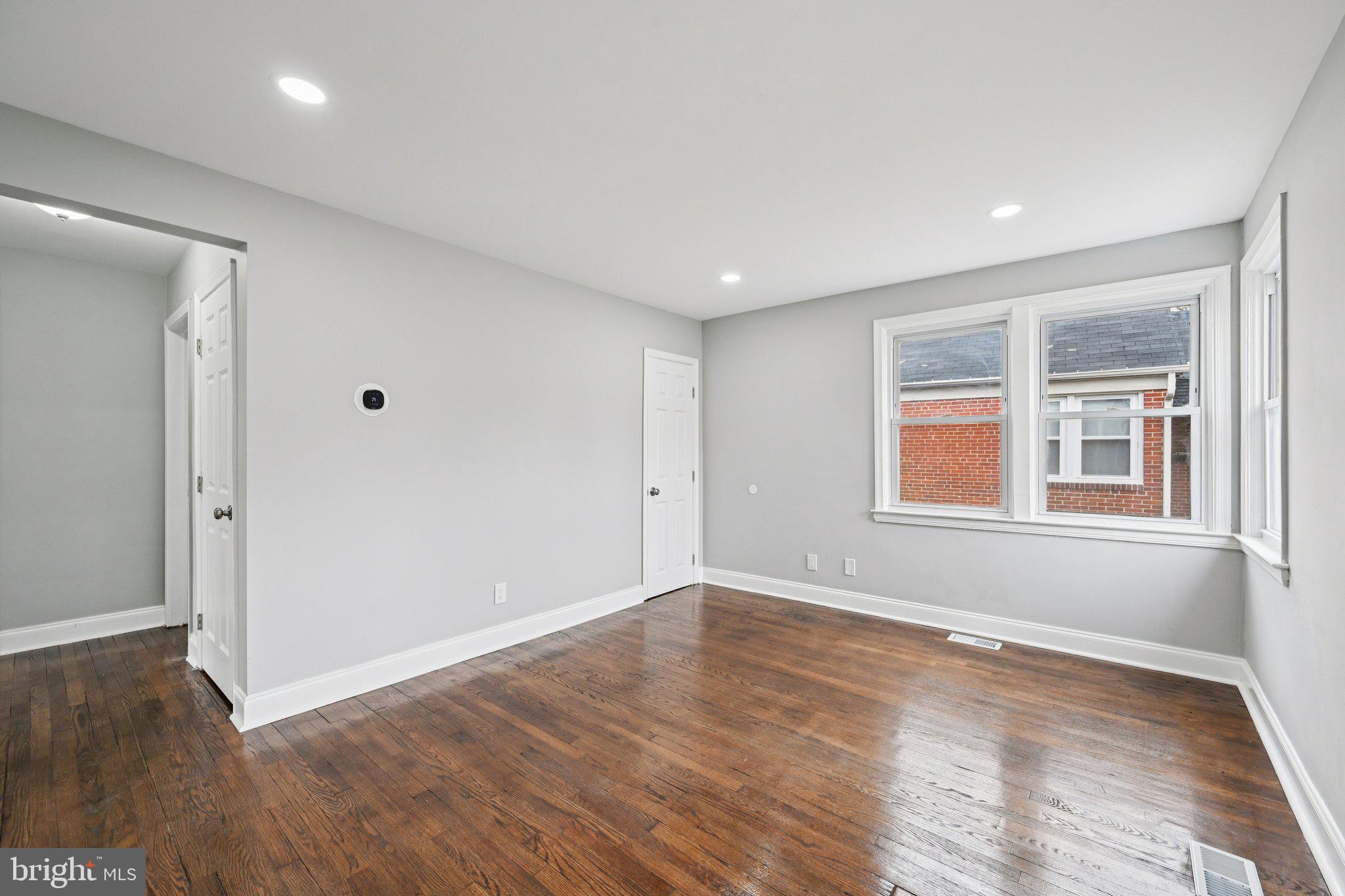 4902 Gilray Drive Baltimore, MD 21214 - Photo 13 of 54 a view of an empty room with wooden floor and a window