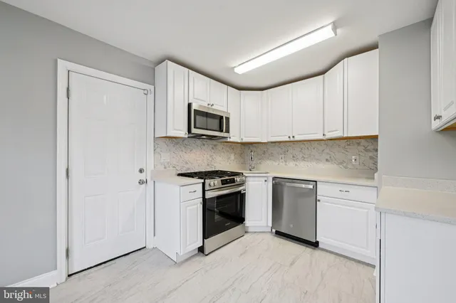 a kitchen with cabinets stainless steel appliances and sink