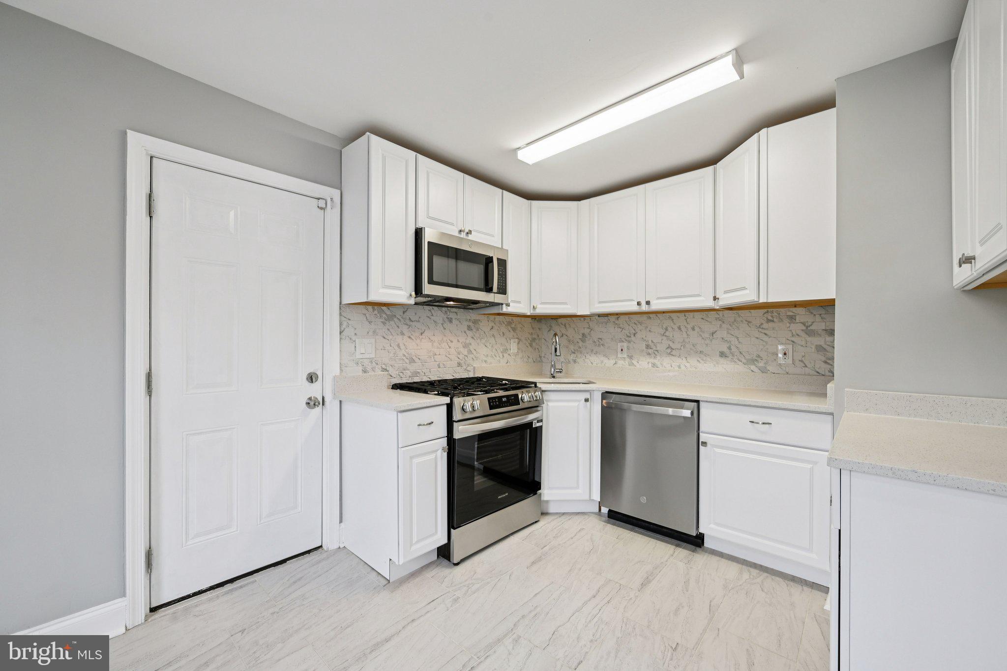 4902 Gilray Drive Baltimore, MD 21214 - Photo 16 of 54 a kitchen with cabinets stainless steel appliances and sink