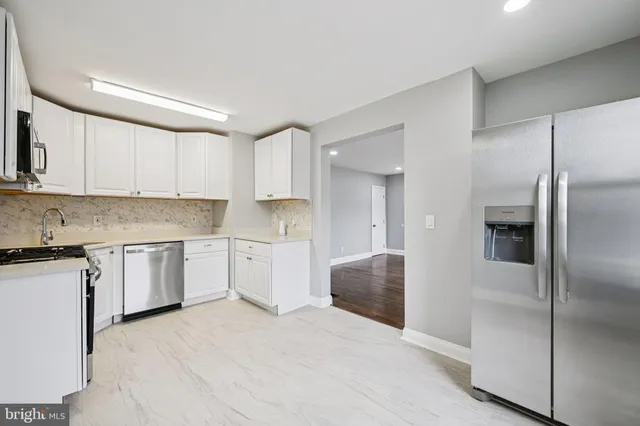 a kitchen with a refrigerator sink and cabinets