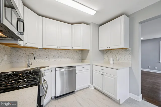 a kitchen with white cabinets and appliances