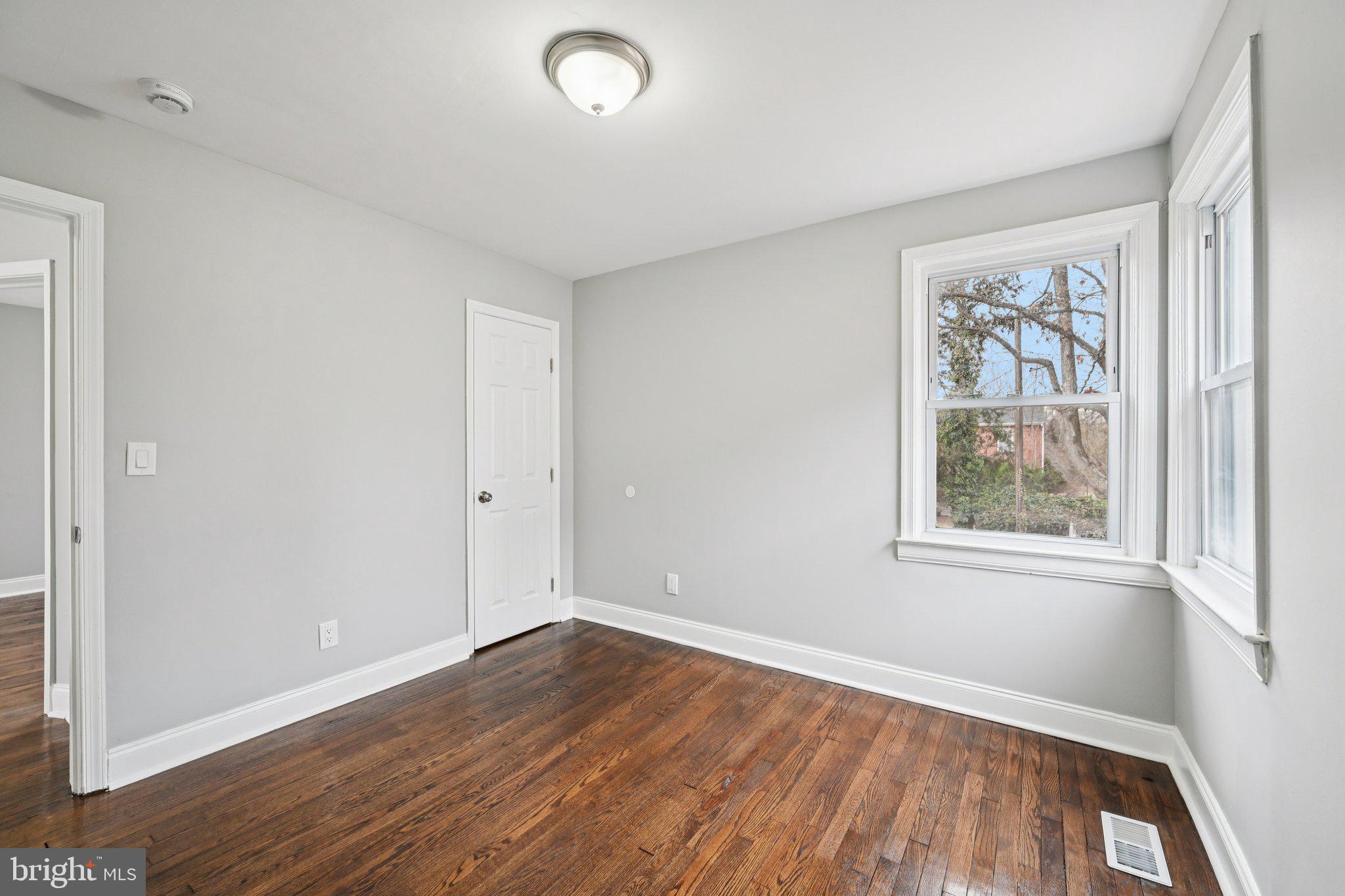 4902 Gilray Drive Baltimore, MD 21214 - Photo 22 of 54 an empty room with wooden floor and windows