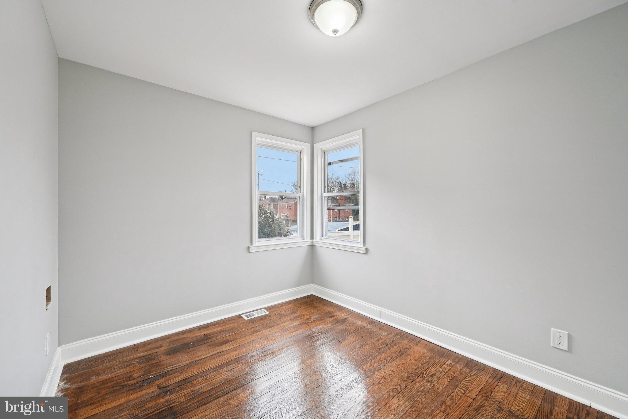 4902 Gilray Drive Baltimore, MD 21214 - Photo 25 of 54 an empty room with wooden floor and windows