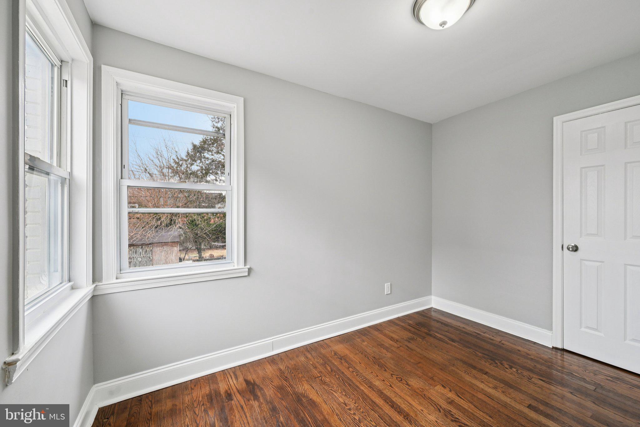4902 Gilray Drive Baltimore, MD 21214 - Photo 26 of 54 an empty room with wooden floor and windows