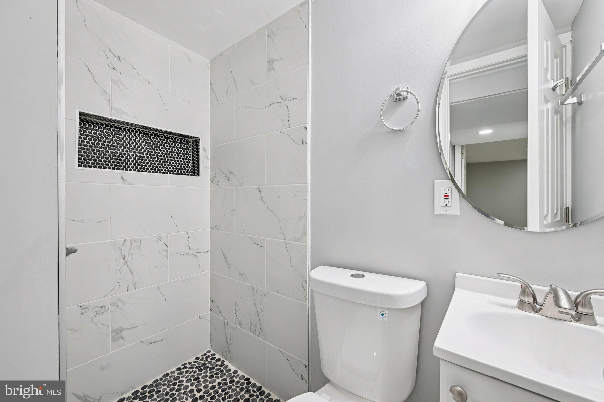 4902 Gilray Drive Baltimore, MD 21214 - Photo 37 of 54 a bathroom with a sink a toilet a shower and a mirror