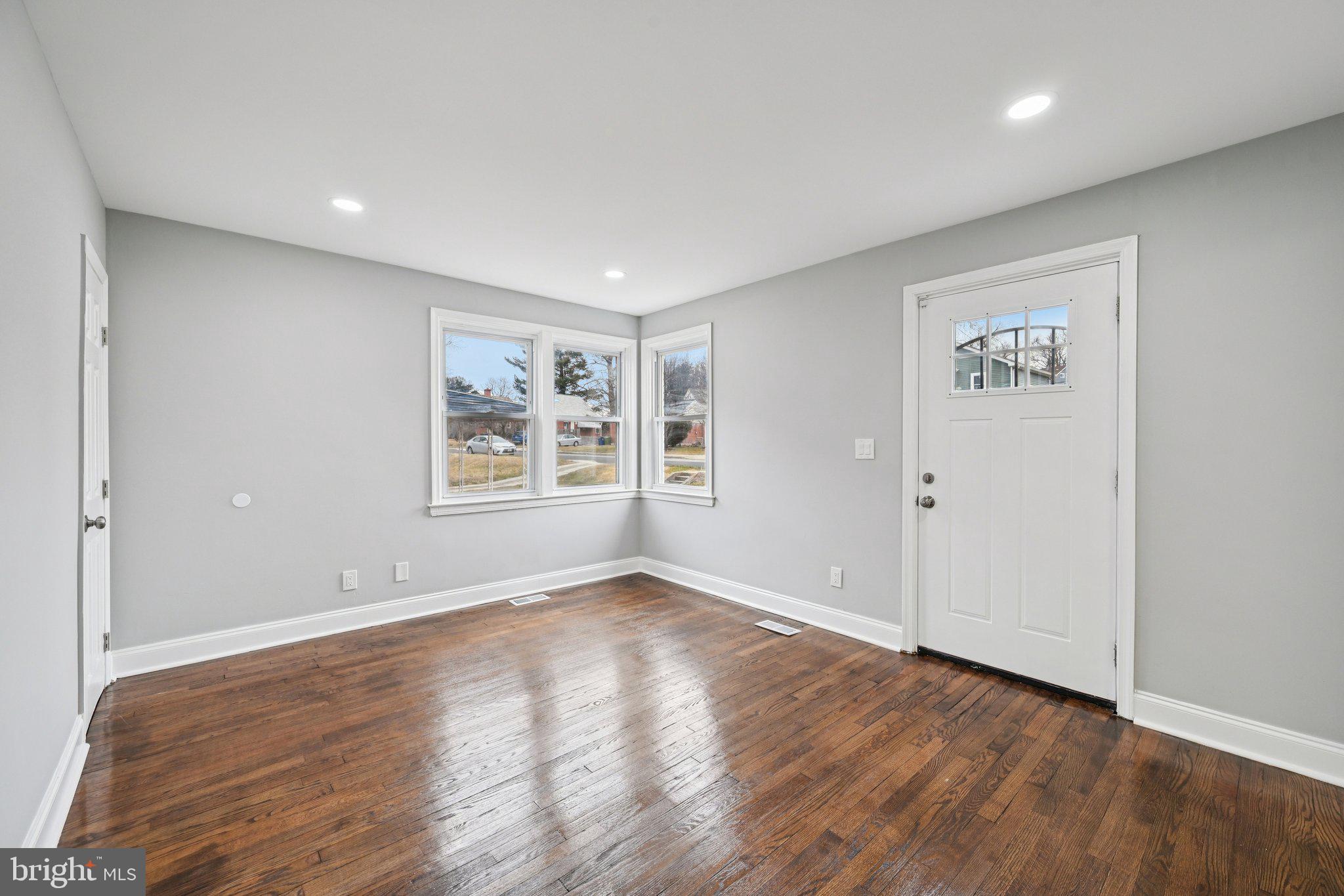 4902 Gilray Drive Baltimore, MD 21214 - Photo 10 of 54 a view of an empty room with window and wooden floor