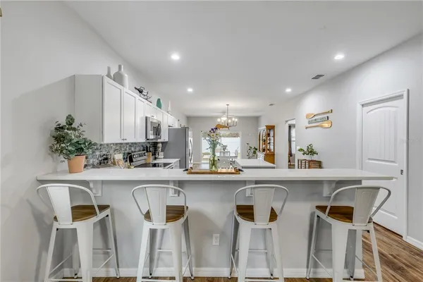 a large white kitchen with sink stove and refrigerator