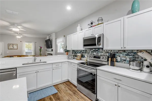a kitchen with white cabinets and stainless steel appliances