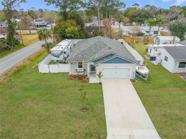 an aerial view of residential houses with outdoor space and trees