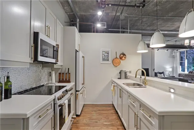 a kitchen with stainless steel appliances granite countertop a sink a stove and chairs