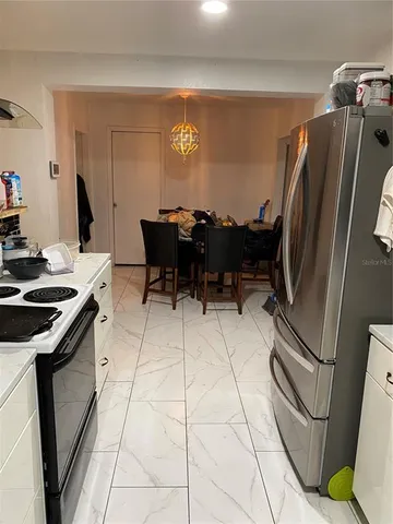 a kitchen with stainless steel appliances granite countertop a refrigerator and a stove