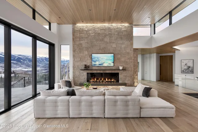 a living room with furniture large window and a fireplace