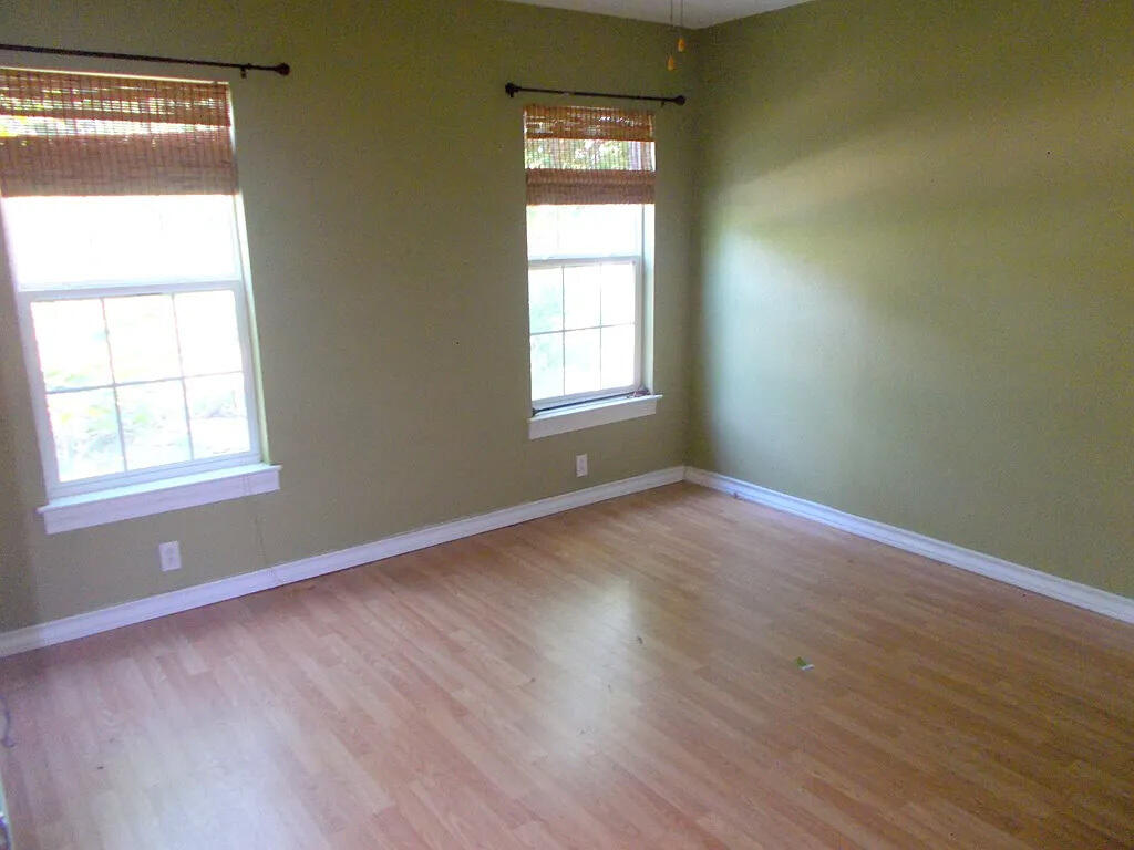 1409 East 11th Place Big Spring, TX 79720 - Photo 6 of 12 a view of an empty room with wooden floor and a window
