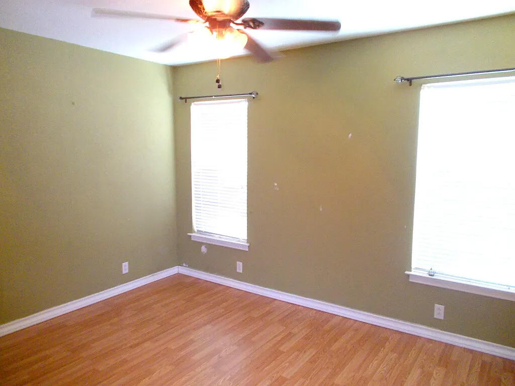 1409 East 11th Place Big Spring, TX 79720 - Photo 7 of 12 an empty room with a window and chandelier fan