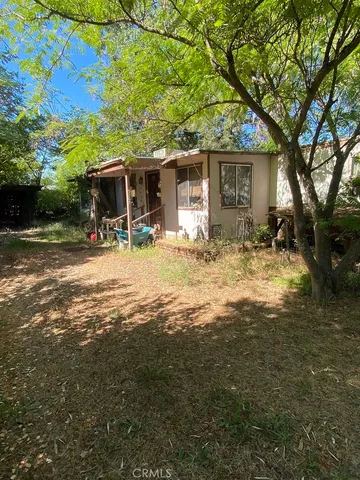 a view of a house with backyard and a tree