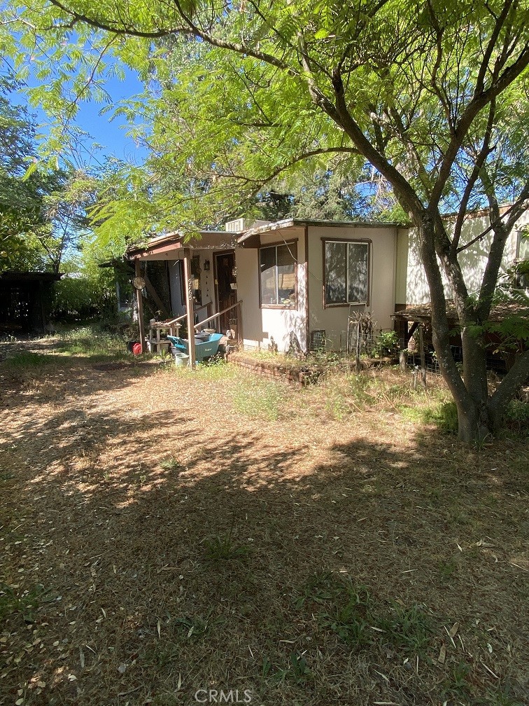 a view of a house with backyard and a tree
